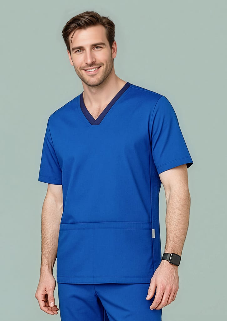 A male model wearing a blue scrub top with a V-neck design and a pocket, featuring a logo. Mens Riley Stretch Scrub Top - Image 1