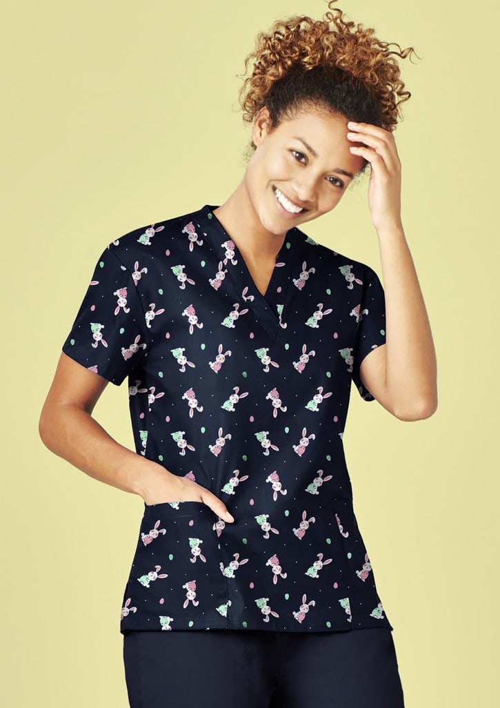 A navy V-neck scrub top featuring a playful Easter-themed pattern, with short sleeves and a pocket. Womens Easter V-Neck Short Sleeve Scrub Top - Image 1