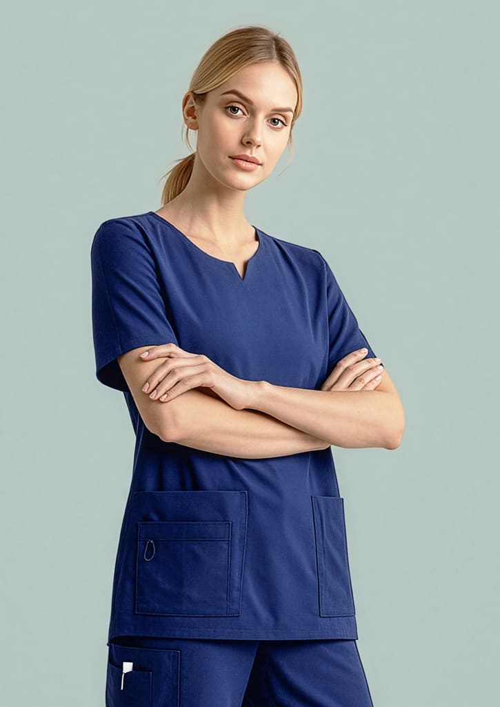 A navy women's scrub top featuring a round neck and two front pockets, styled with a model. Womens Avery Round Neck Scrub Top - Image 1