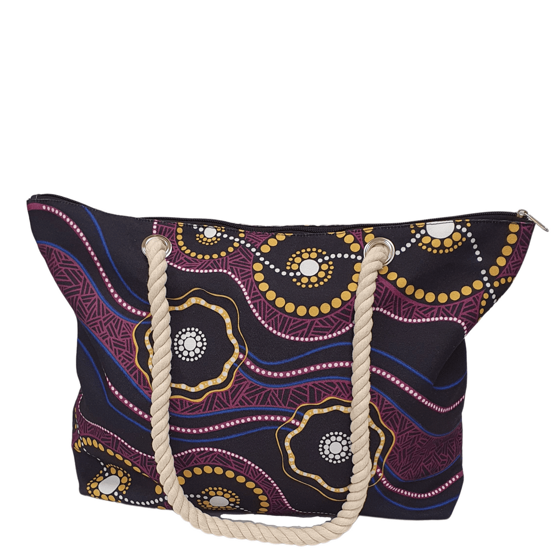 A tote bag featuring a black design with vibrant patterns in gold, purple, and red. It has rope handles and a zip closure. Cullunghutti Beach Bag - Image 1