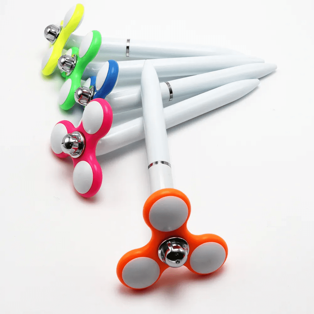 A collection of hand spinner pens in various colours: green, blue, pink, orange, and yellow, with white accents. Hand Spinner Pen - Image 1