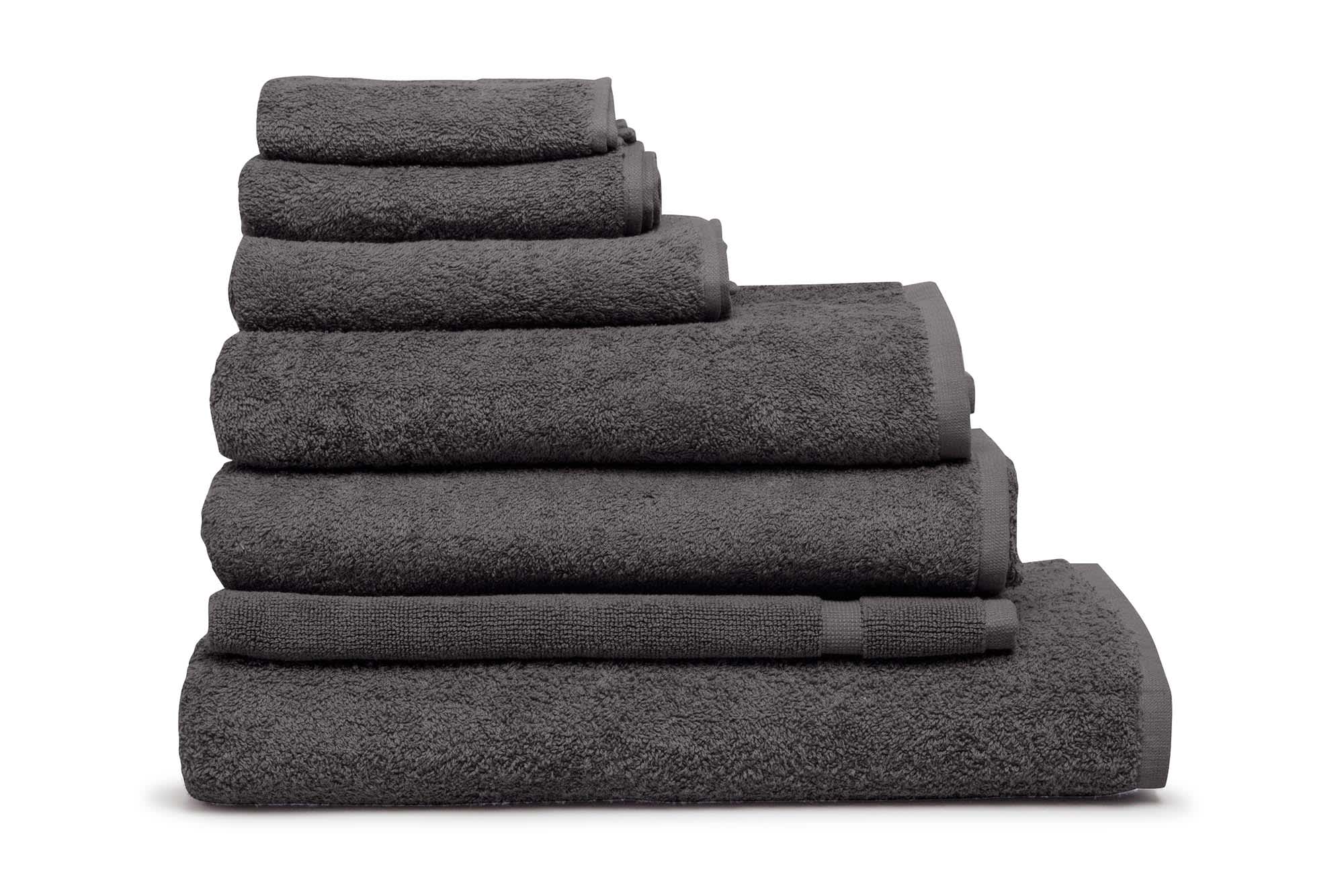 A stack of grey towels in various sizes, showcasing a plush texture and a simple design. The image includes branding. Elite Face Washer 500 gsm Coal - Image 1