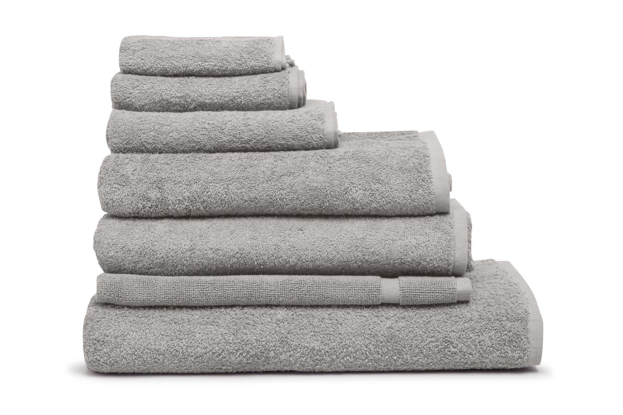 A stack of grey bath mats in varying sizes, featuring a soft texture and a simple design. Elite Bath Mat 500 gsm Silver - Image 1
