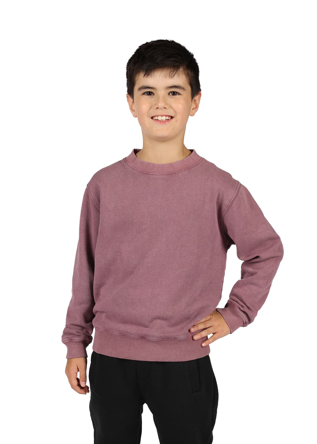 A unisex stone wash sweatshirt in a muted mauve colour, worn by a smiling child with dark hair, standing in a casual pose. Kids' Stone Wash Sweatshirts - Image 1