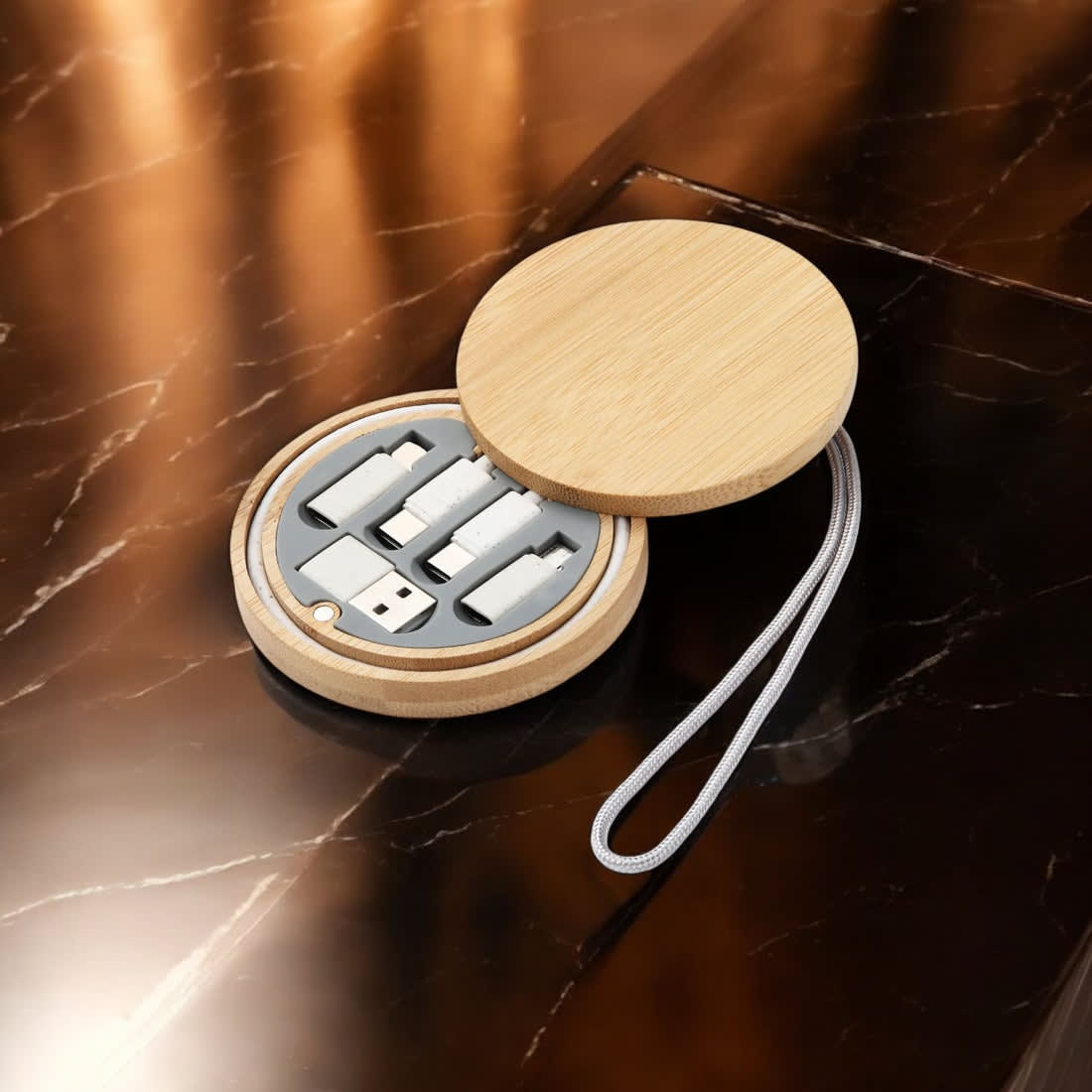 A circular bamboo case containing multiple charging and data cables in grey and silver, with a strap attached. Globe Charging & Data Cable Kit - Image 1