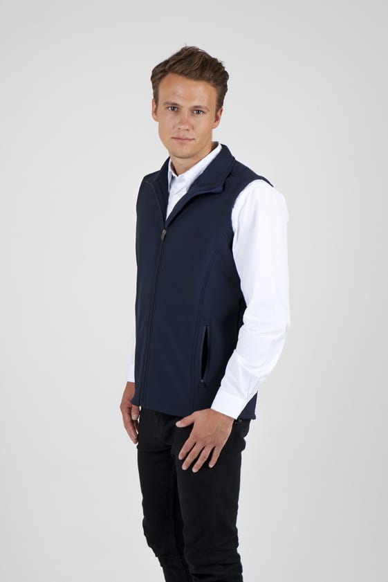 A man wearing a navy blue soft shell vest, standing against a plain background, with a zip and pockets. Men's Soft Shell VEST - TEMPEST Range - Image 1