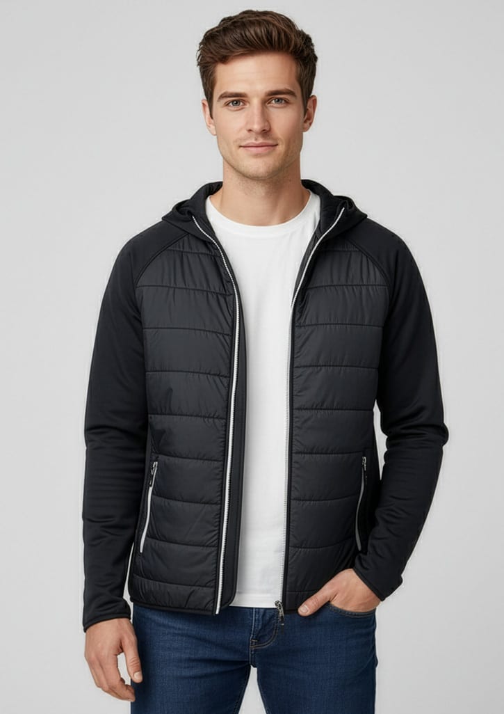 A man wearing a black puffer jacket with a hood, paired with a white t-shirt and blue jeans. The jacket has a logo. Mens Stealth Jacket - Image 1