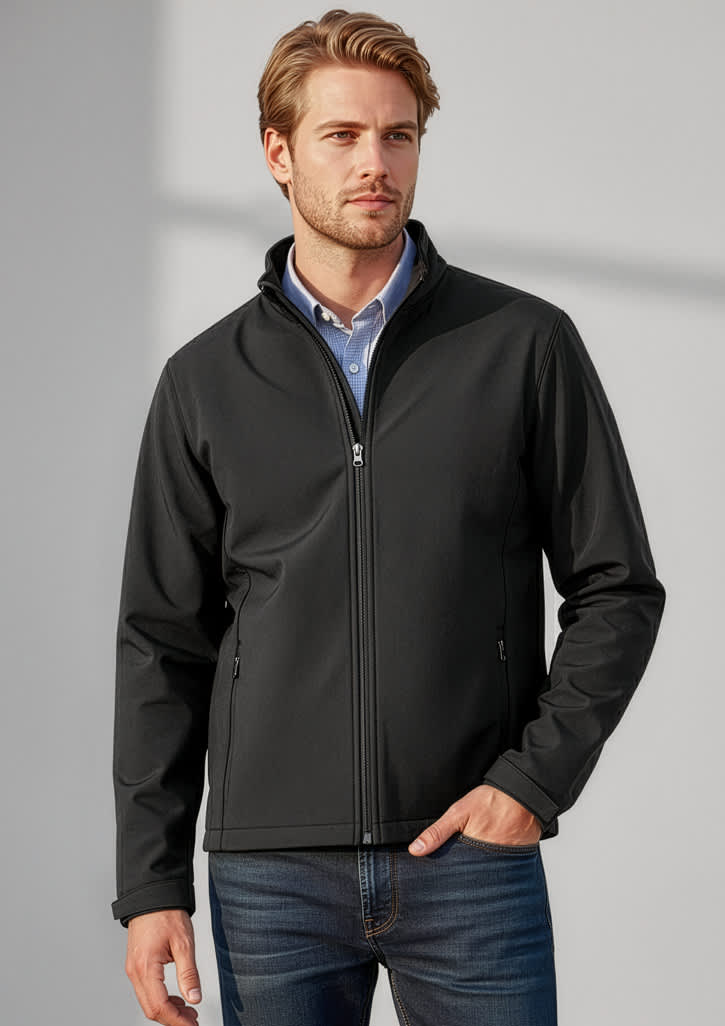 A man wearing a black soft shell jacket, standing against a neutral background, featuring a logo on the jacket. Mens Apex Jacket - Image 1