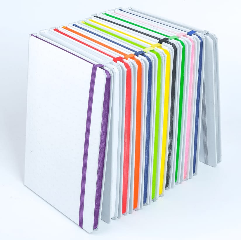 A stack of colourful notebooks in various hues, featuring a mix of white, neon, and pastel covers. Thornton Notebook - Image 1