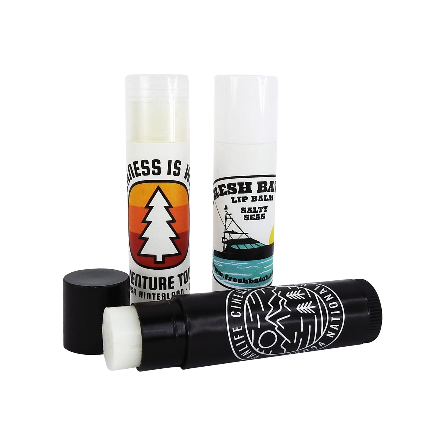 Three lip balm twist tubes in various designs and colours, including black, white, and green, with one featuring a logo. Lip Balm Twist Tube - Image 1