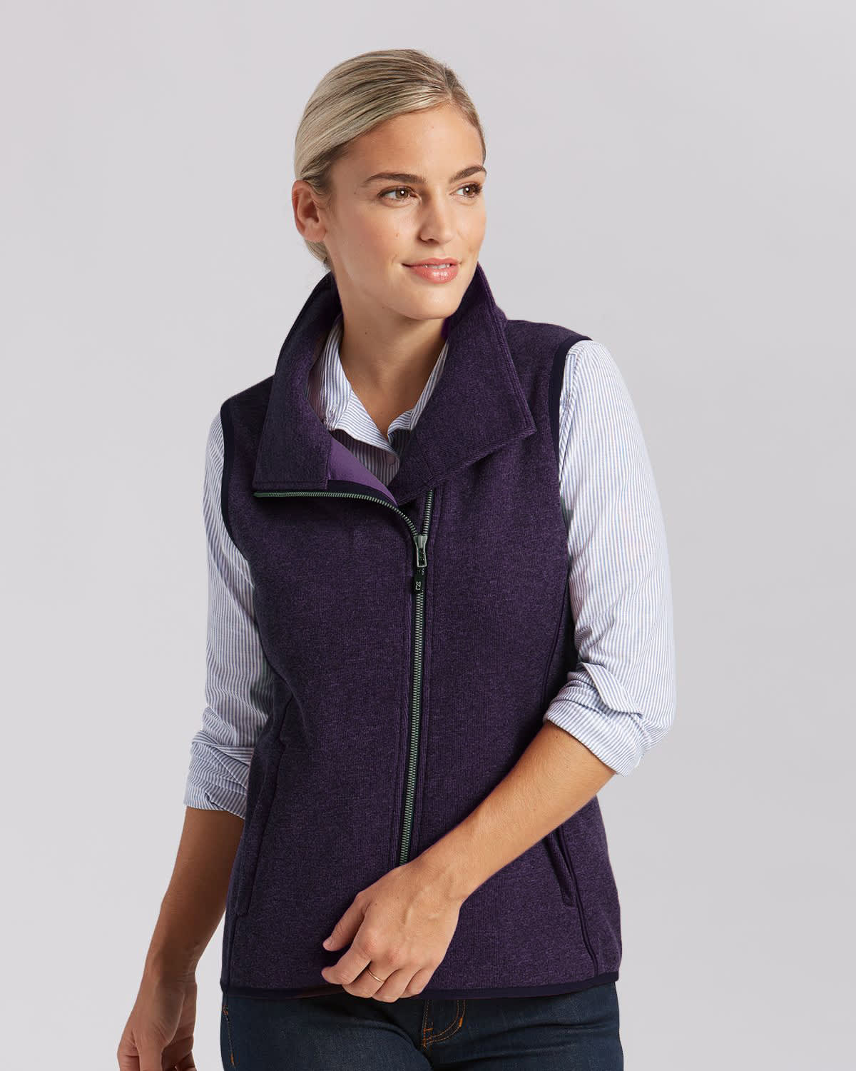 A purple ladies vest featuring a high collar and front zip, worn over a striped shirt. Includes a logo. Ladies Mainsail Vest - Image 1