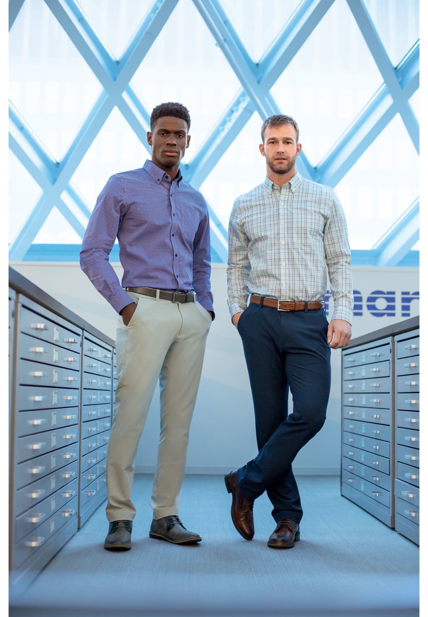 Two men standing in a bright space, wearing a patterned purple shirt and a plaid shirt with beige and navy pants. CB DryTec Bainbridge Sport Pant - Image 1