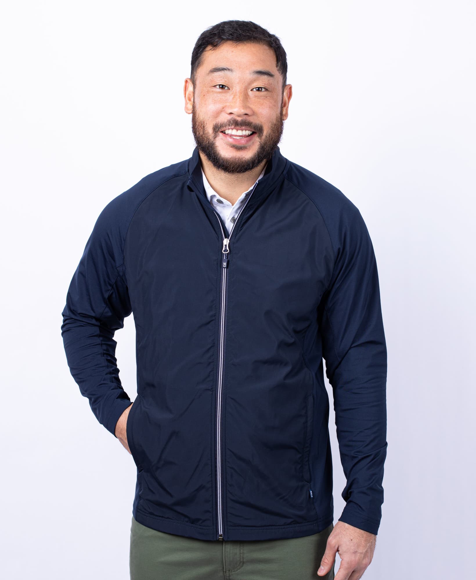 A man wearing a navy blue full zip jacket with a zippered front and a logo. The jacket features long sleeves. Men's Adapt Full Zip Jacket - Image 1