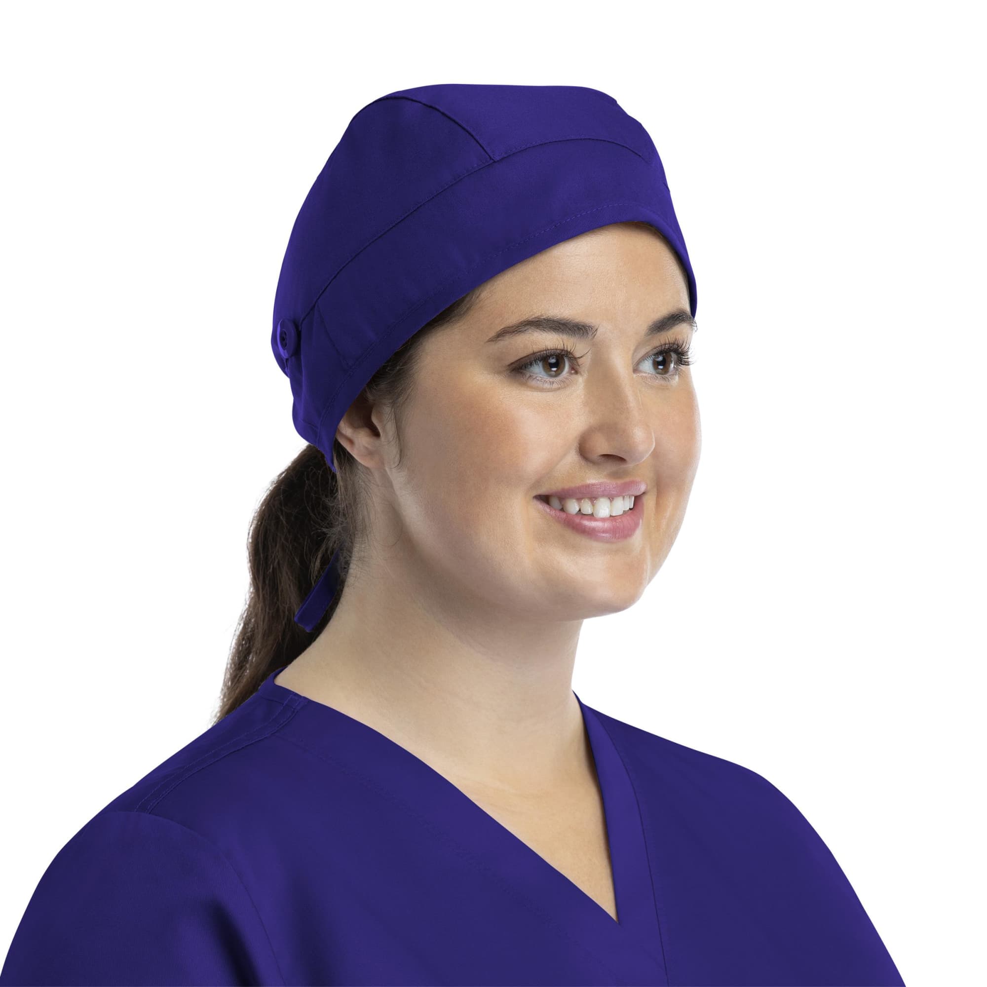 A unisex scrub cap in purple with buttons, worn by a smiling woman in a scrub top. Scrub Cap Unisex Cap With Buttons - Image 1