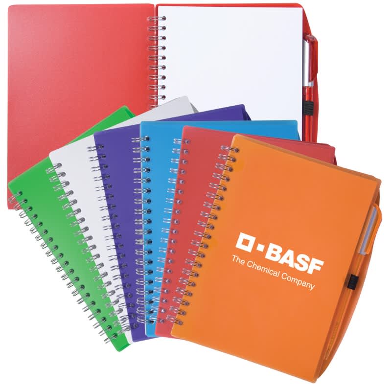 Spiral notebooks in various colours including red, green, blue, purple, and orange, accompanied by a pen, featuring a logo. Spiral Notebook w/Pen - Image 1