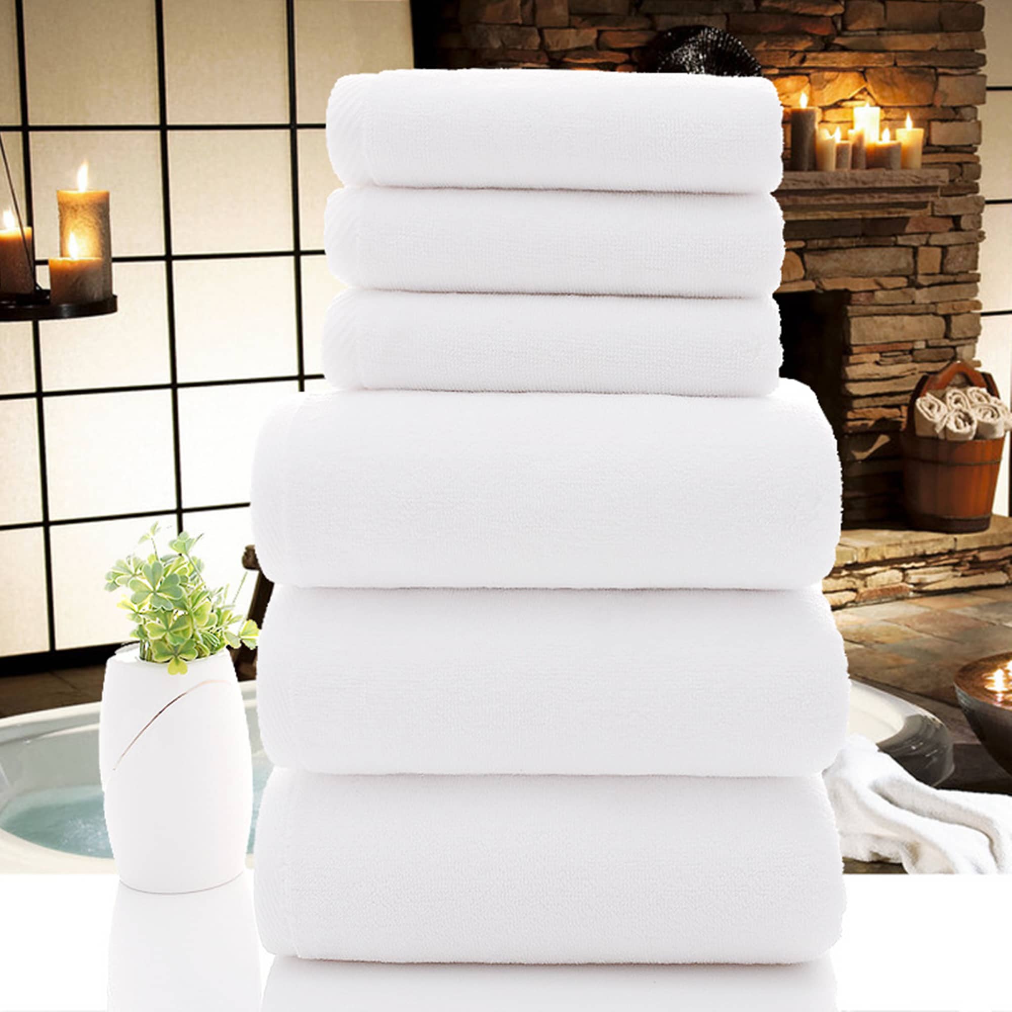 A stack of plush white towels arranged neatly, set against a tranquil spa-like background. Hotel Towels - Image 1