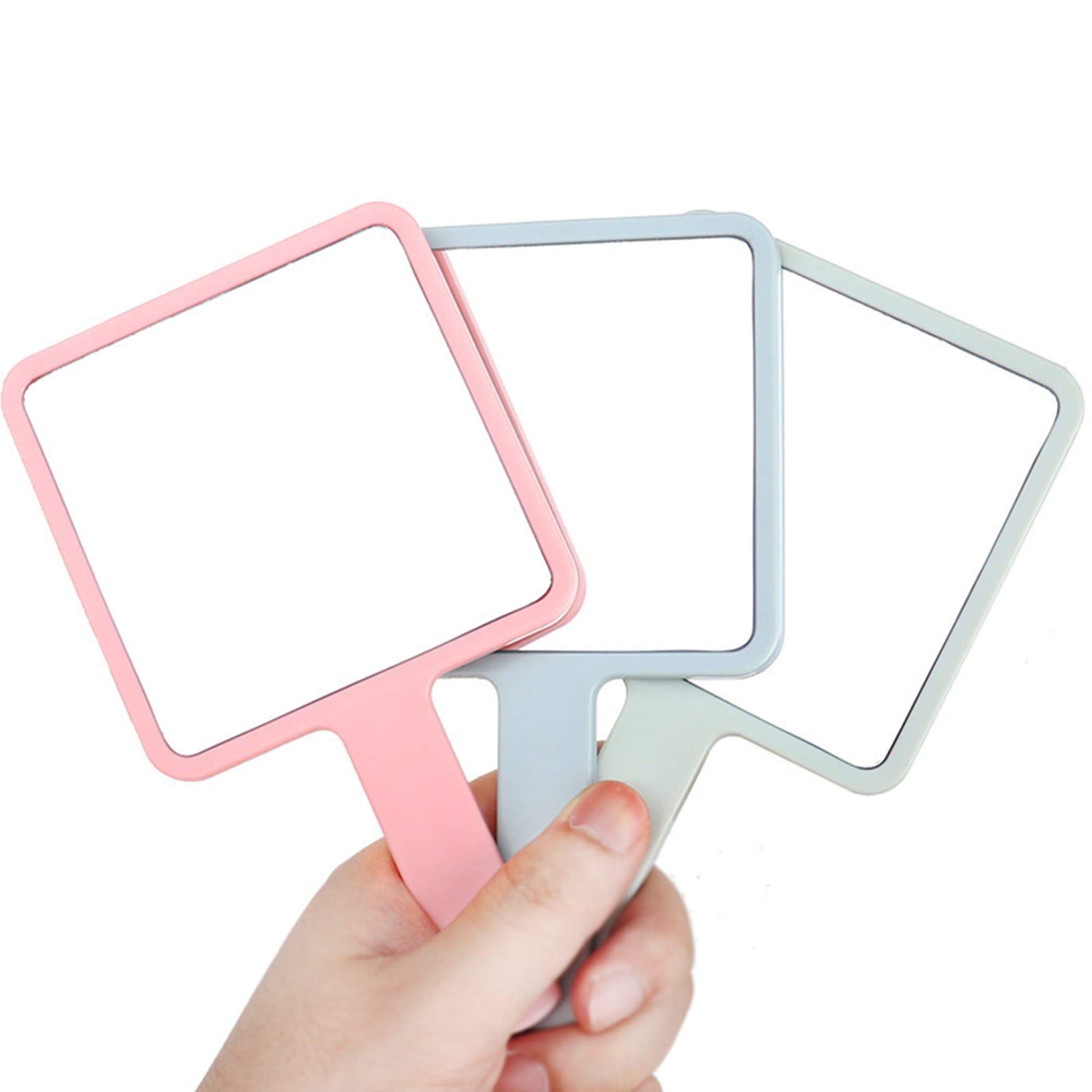 A set of three square handheld mirrors in pink, blue, and green held by a hand, with a simple design. Square Handheld Mirror - Image 1