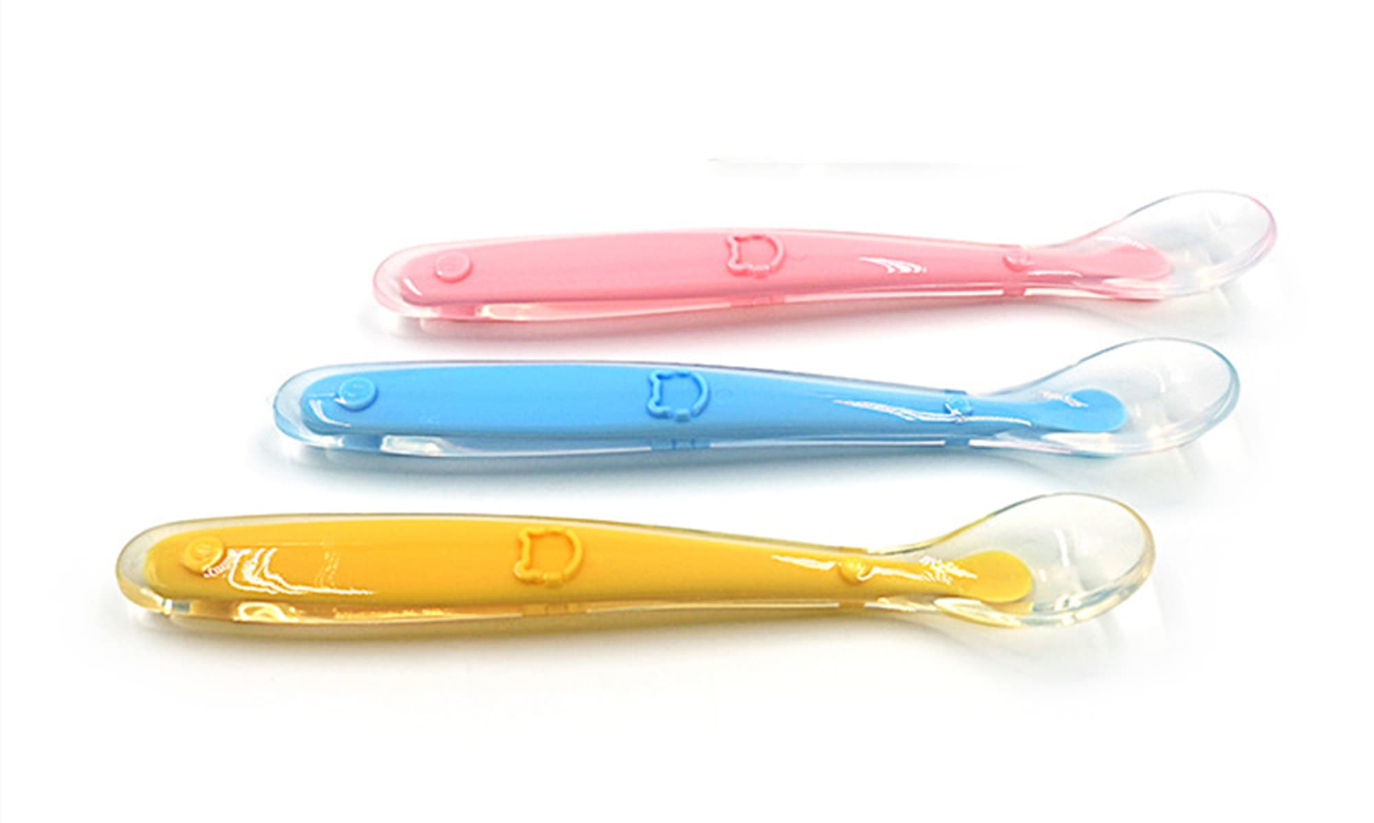 Three baby training spoons in pink, blue, and yellow, featuring a soft, curved design and a small handle. Baby Training Spoon - Image 1