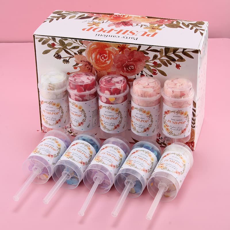 A set of eight Push Pop Confetti containers in various colours, presented in a decorative box with floral designs. Push Pop Confetti - Image 1