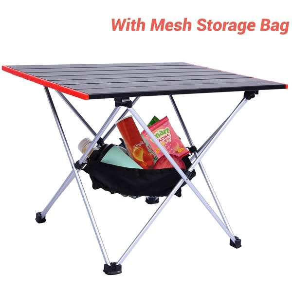 A portable camping table with a black top, red edges, and a mesh storage bag underneath filled with items. Portable Camping Tables - Image 1