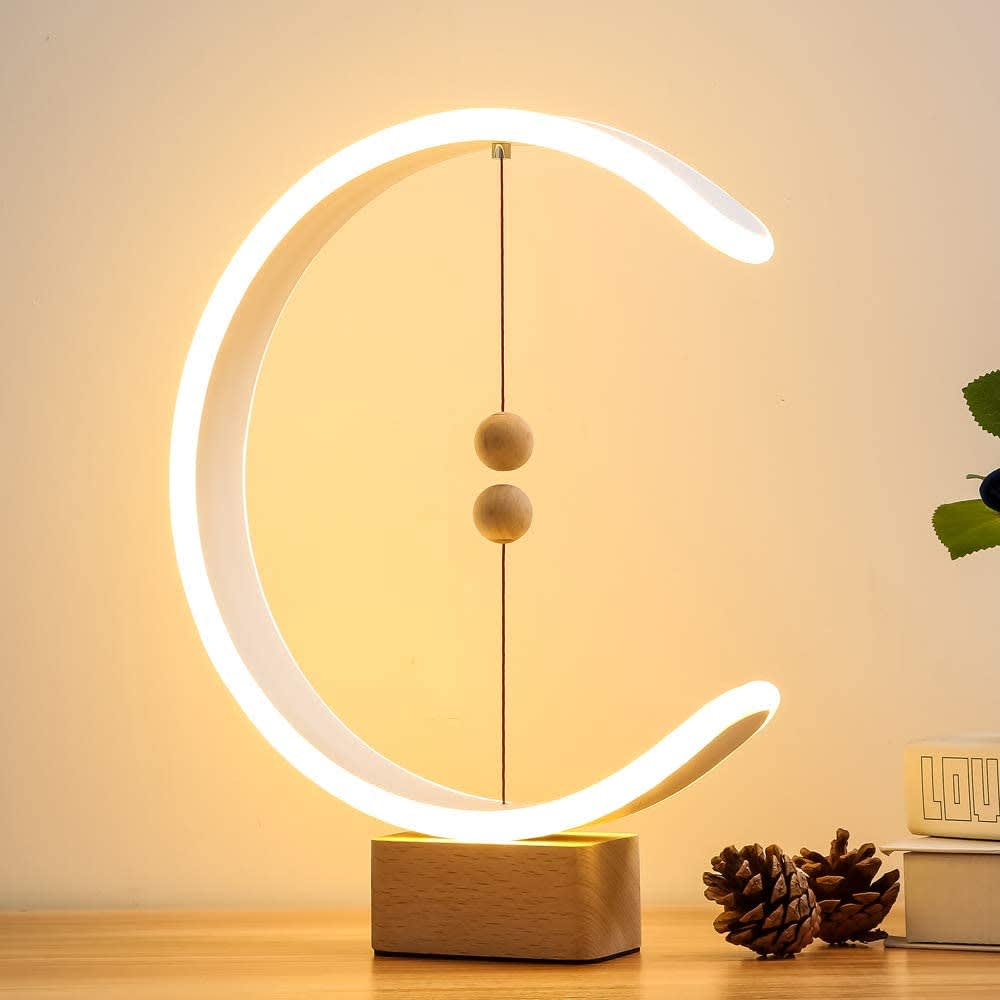 A modern balance lamp in a circular design with glowing white light, featuring wooden accents and a wooden base. Smart Magnetic Suspension Balance Lamp - Image 1