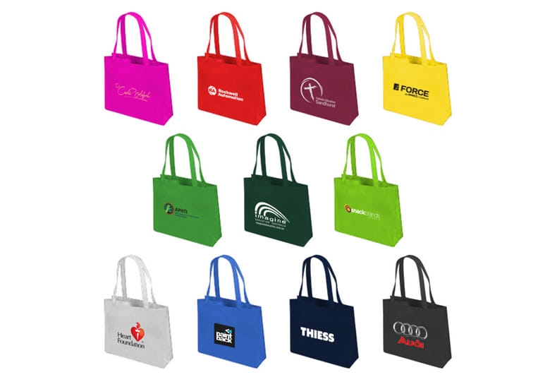 A variety of tote bags in different colours including pink, yellow, green, blue, and black, featuring various logos. Renwick Boutiquer Bag - Image 1