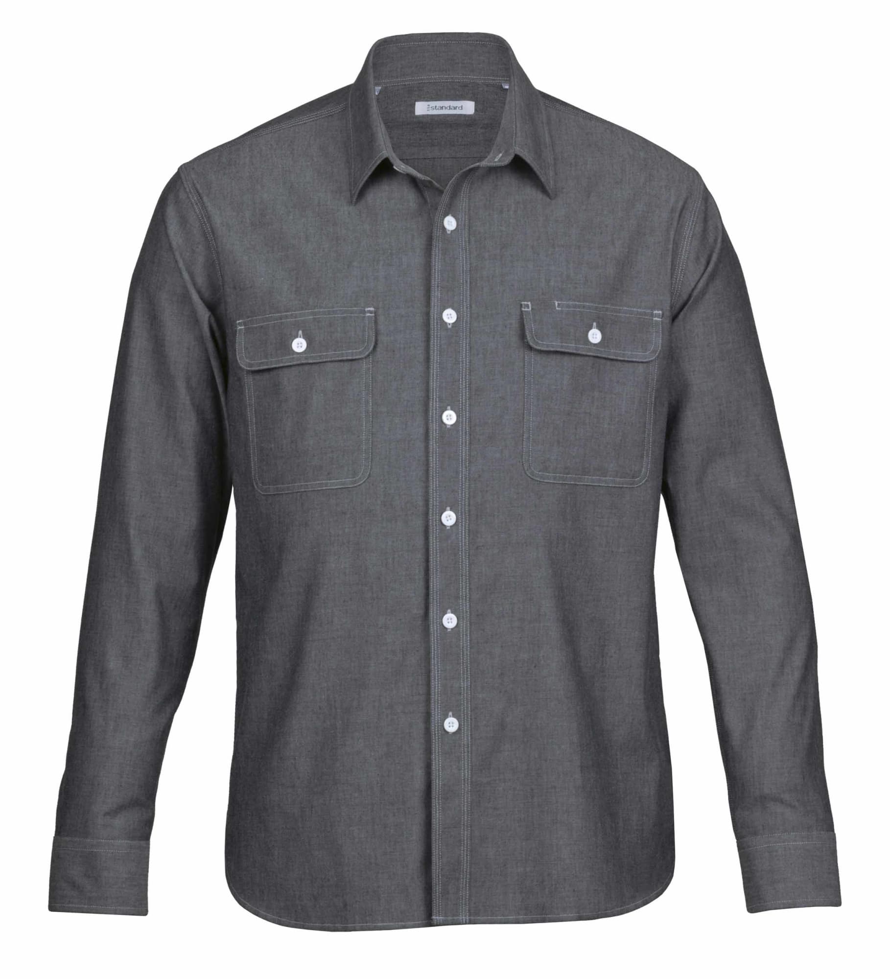 A men's button-up shirt in grey chambray fabric featuring two chest pockets and a collar. It has a logo detail. The Montreal Chambray Shirt - Mens - Image 1