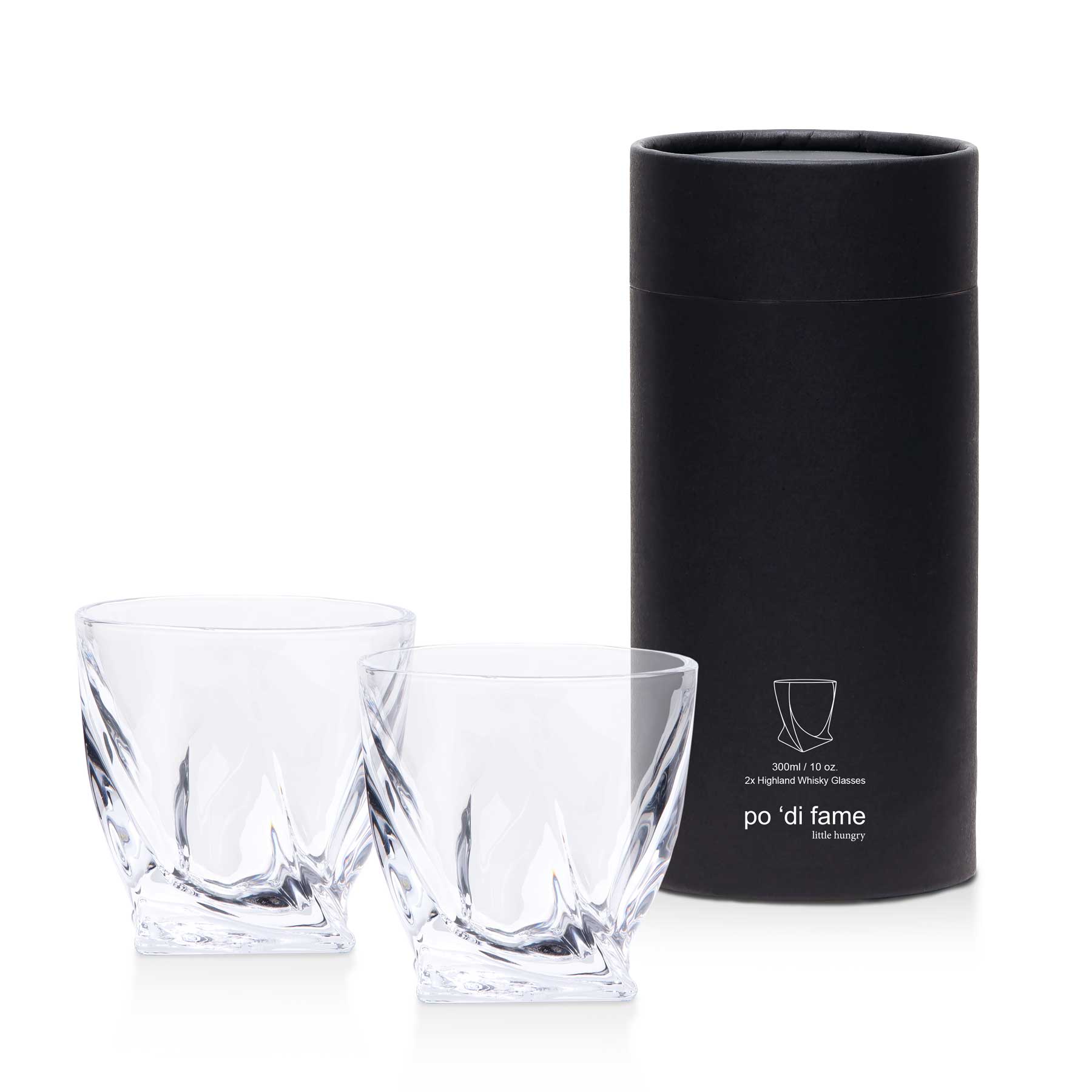 A whisky glass set featuring two clear, intricately designed glasses packaged in a sleek black cylindrical box. Highland Whisky Glass Set - Image 1