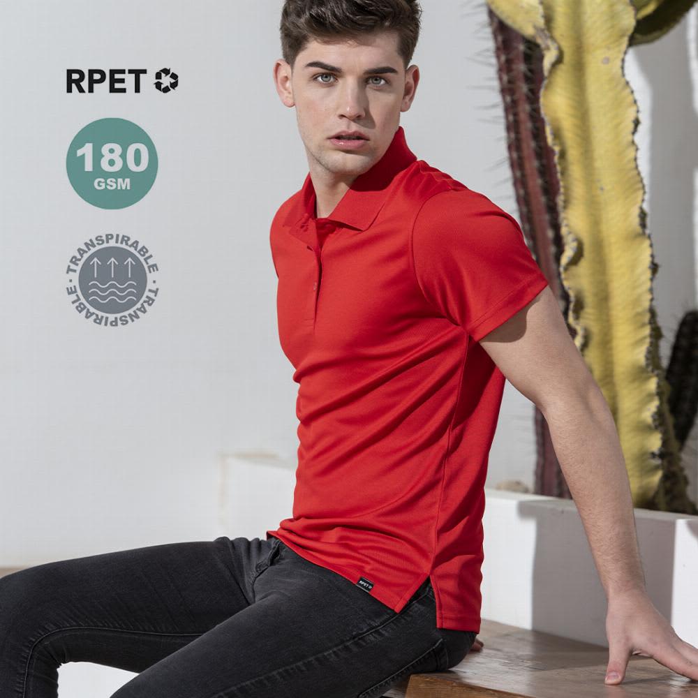 A red polo shirt is worn by a model sitting on a bench, with cacti in the background. The shirt has a logo. Dekrom - Image 1