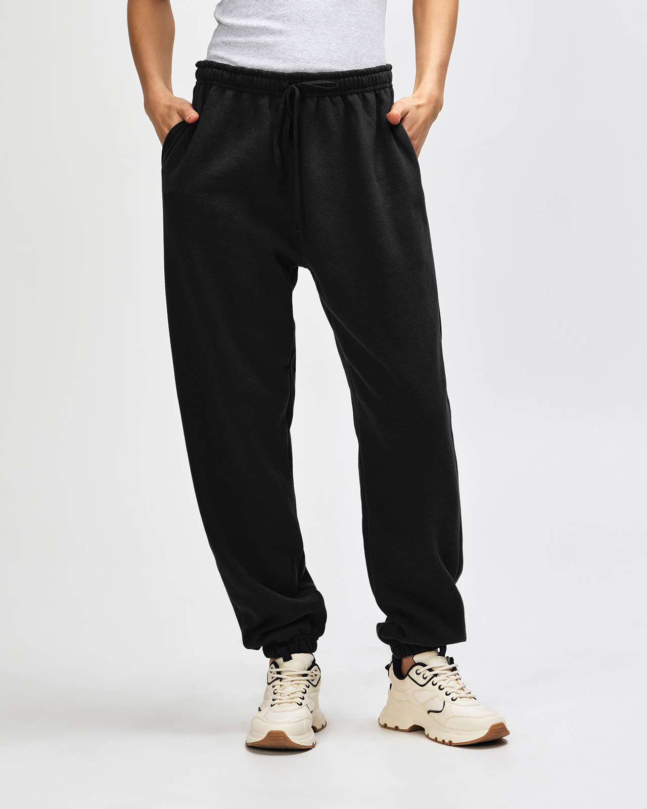 Black unisex sweatpants with an elastic waistband and drawstring, featuring a logo on the side. American Apparel Reflex Fleece Unisex Sweatpants - Image 1