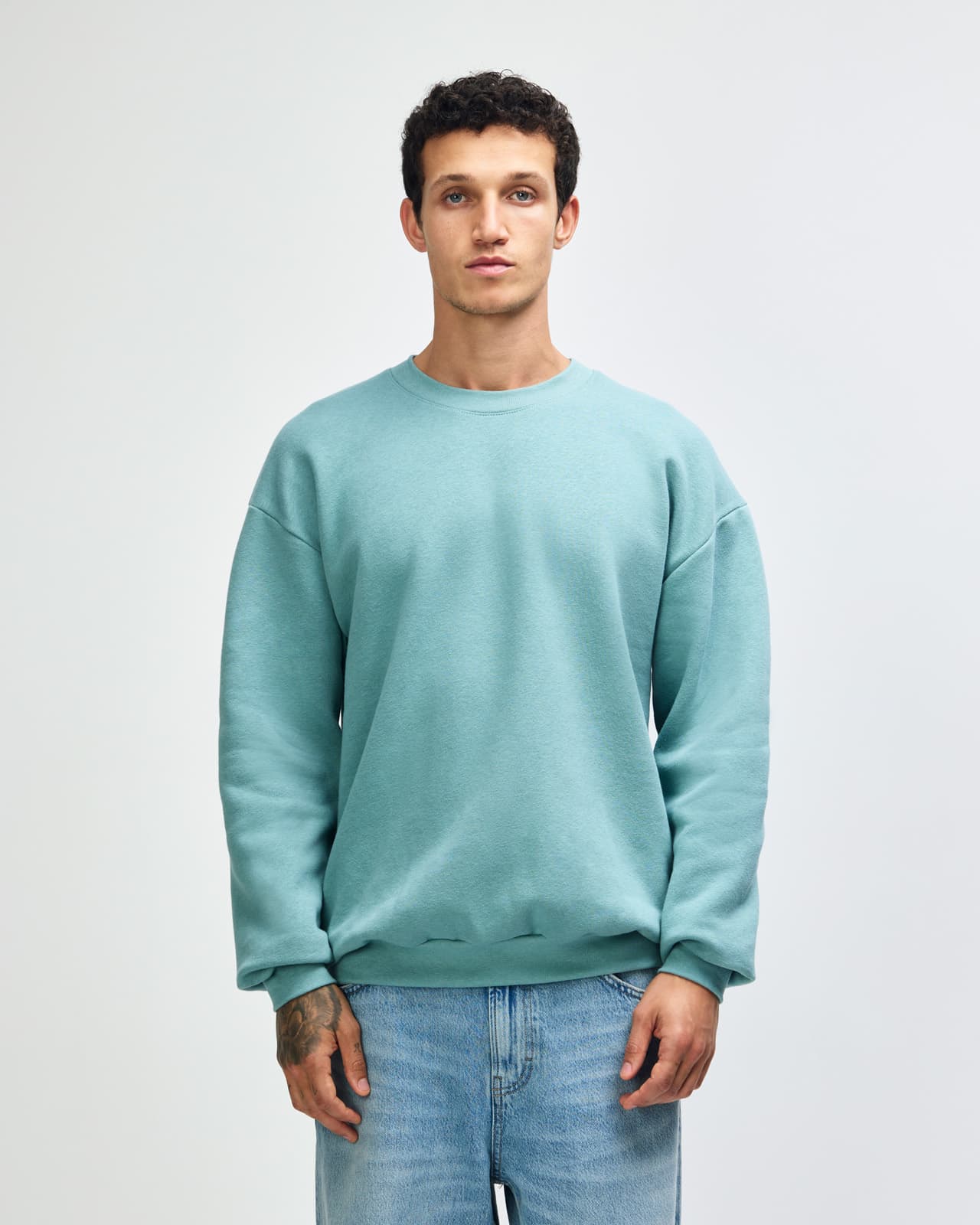 A unisex crewneck sweatshirt in a soft green hue, featuring long sleeves and relaxed fit. Contains branding. American Apparel Reflex Fleece Unisex Crewneck Sweatshirt - Image 1