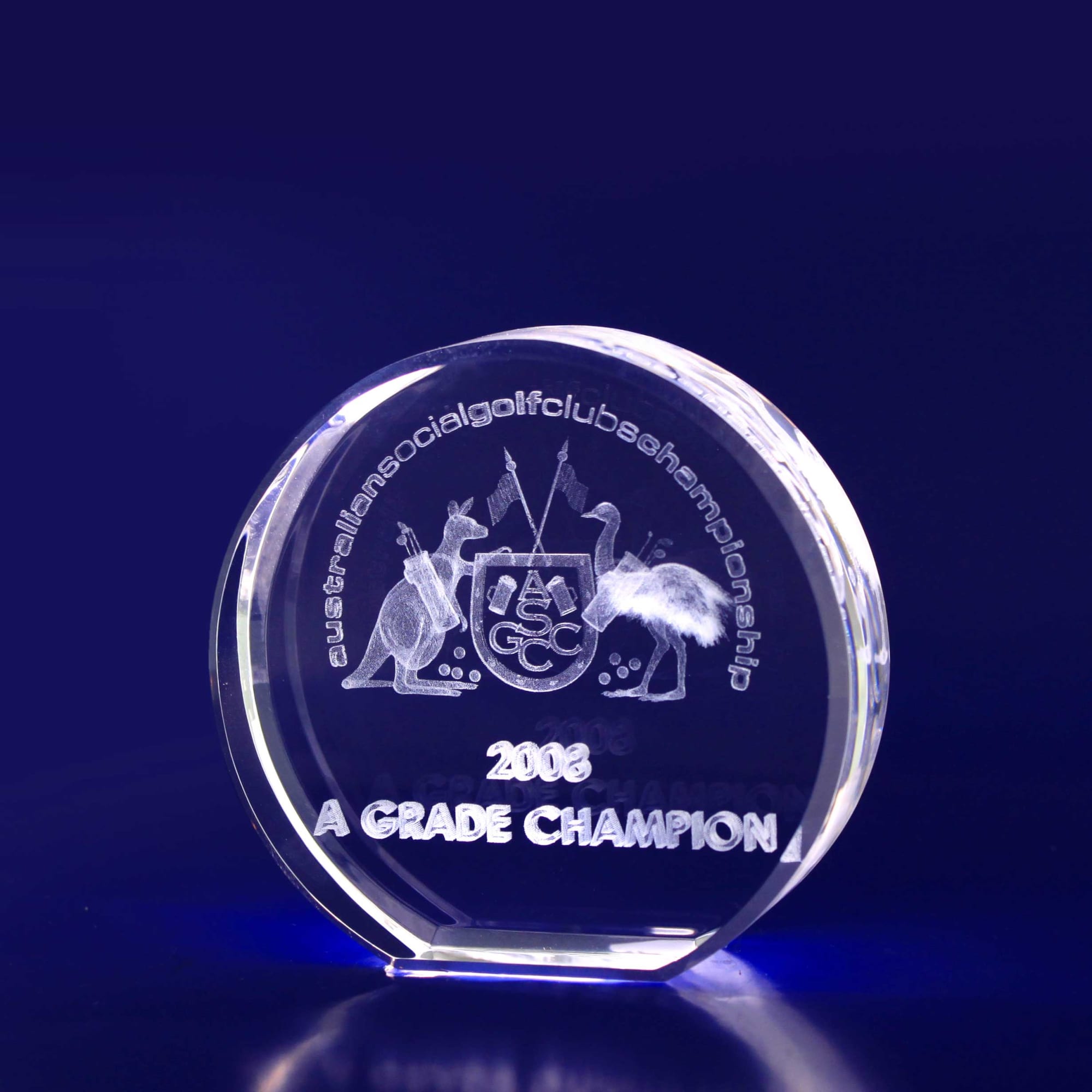 A round, clear crystal trophy with engraved details, featuring a logo and text highlighting "A Grade Champion" for 2002. 3D Crystal Round (70mm diametre) - Image 1
