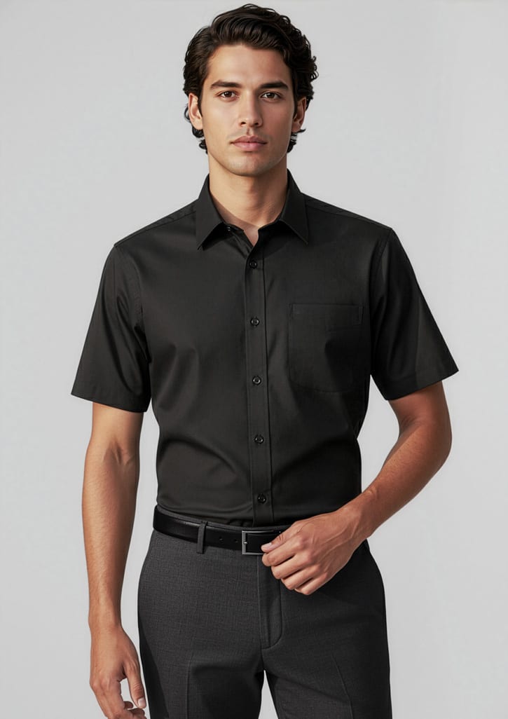 A short-sleeve black button-up shirt on a male model, featuring a chest pocket and a sleek design. Mens Base Short Sleeve Shirt - Image 1