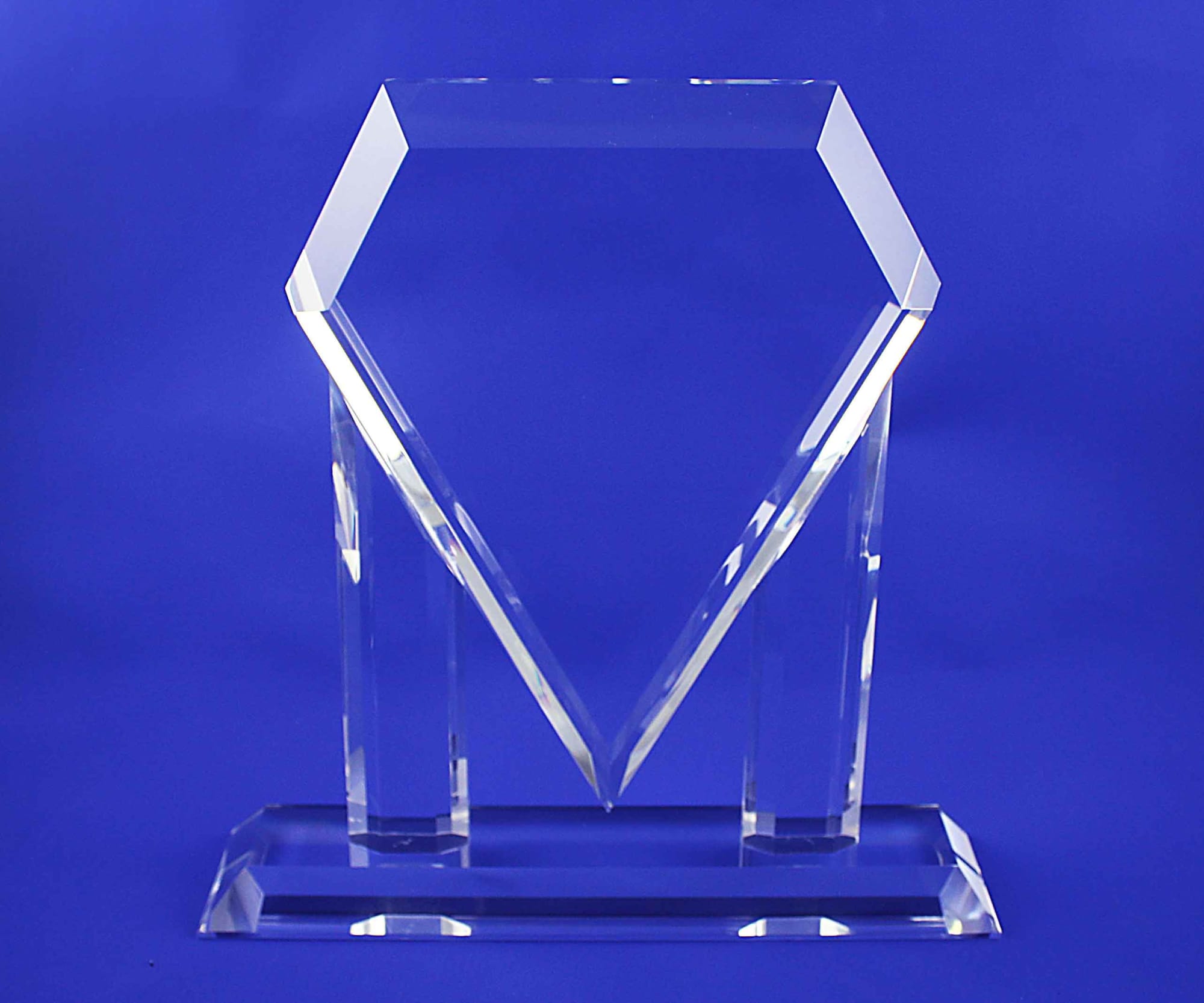 A clear, crystal trophy with a unique diamond shape, set against a blue background. 3D Crystal SM Trophy - Image 1