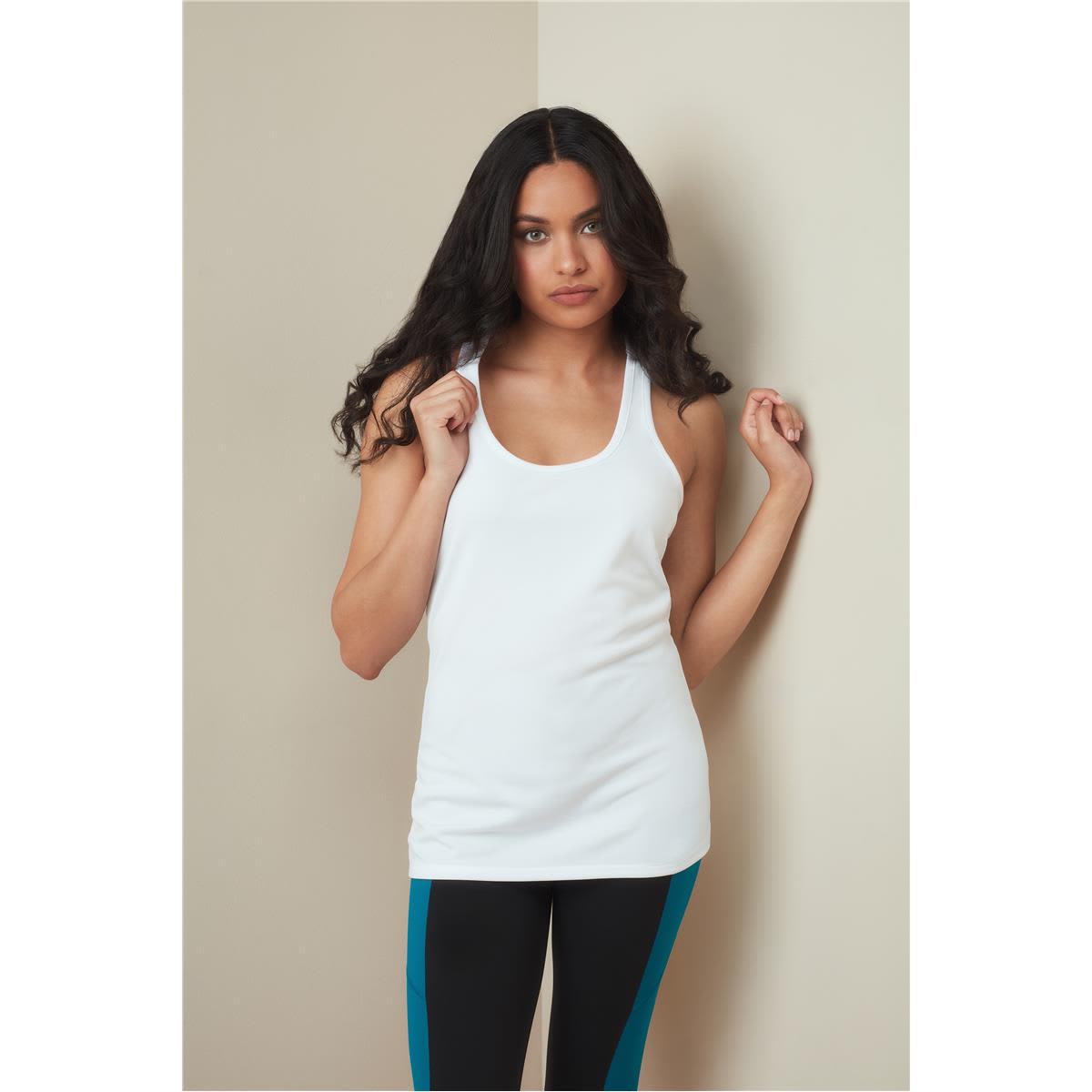 A woman models a white tank top, paired with black leggings featuring turquoise stripes. The top has a logo. Women's Active 140 Tank - Image 1