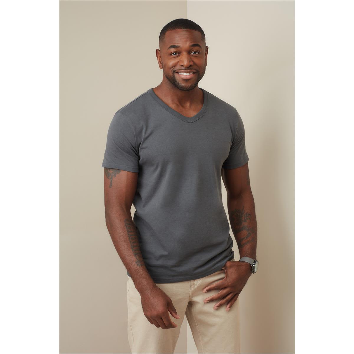 A man in a grey V-neck t-shirt stands against a neutral background, smiling and wearing light-coloured pants. Men's Ben V-neck - Image 1