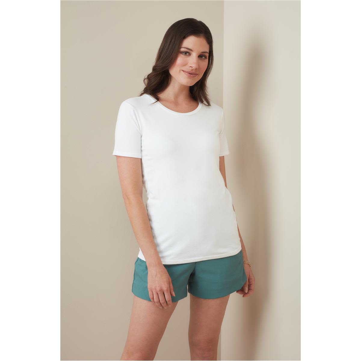 A woman stands wearing a white crew neck t-shirt paired with teal shorts. The shirt features a logo. Women's Relax Crew Neck - Image 1