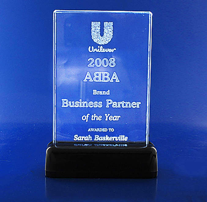 A clear 3D crystal plaque with a black base, featuring branding and text related to an award. 3D Crystal Small Studio Plaque - Image 1