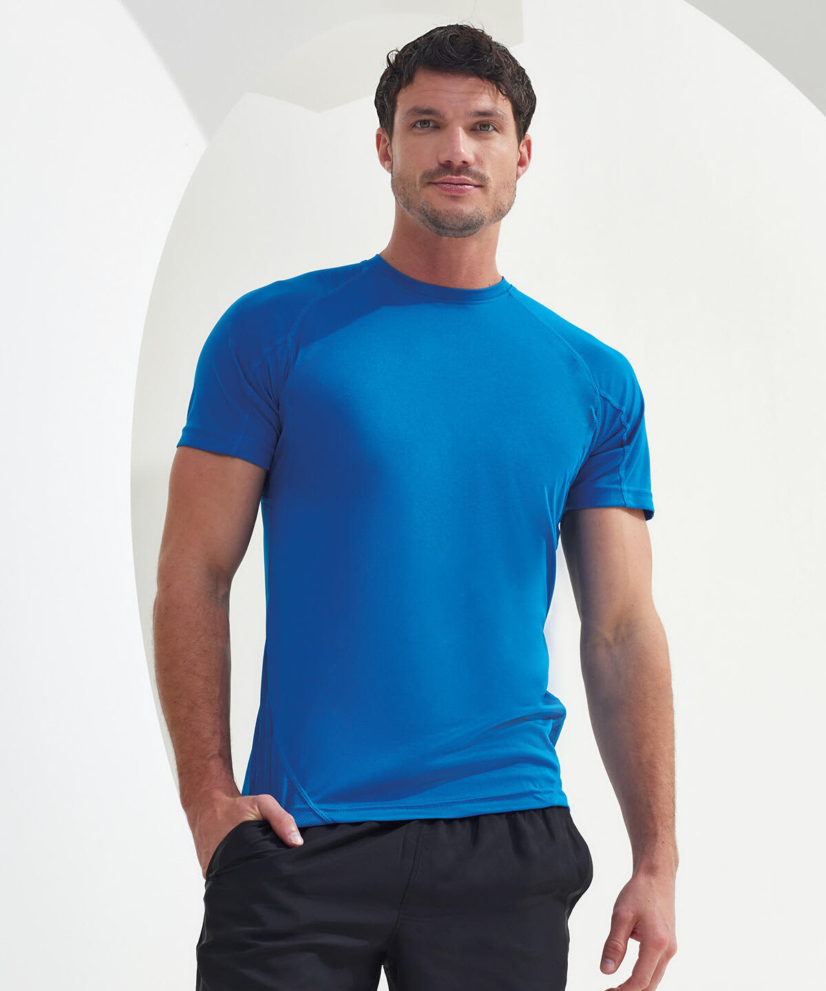 A panelled tech T-shirt in bright blue, featuring a fitted design and short sleeves. The model poses against a neutral background. Panelled Tech T-Shirt - Image 1