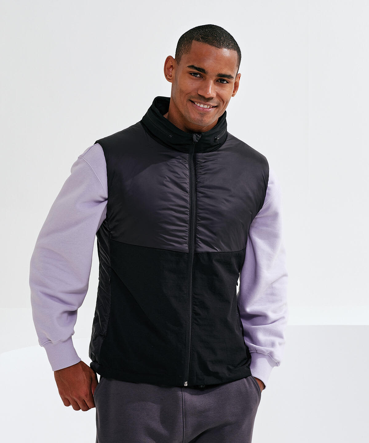 A black and purple insulated hybrid gilet, featuring a zip front and a stand collar, with a branded logo. Insulated Hybrid Gilet - Image 1