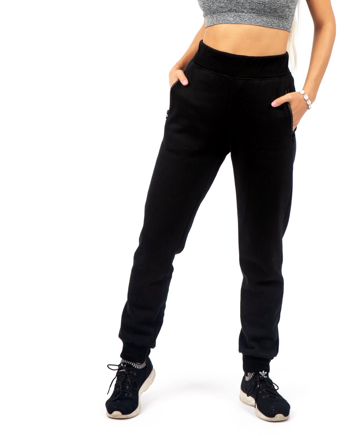 Brushed fleece track pants in black featuring pockets and a relaxed fit, paired with sporty sneakers. Womens' STANCE brushed fleece pants - Image 1