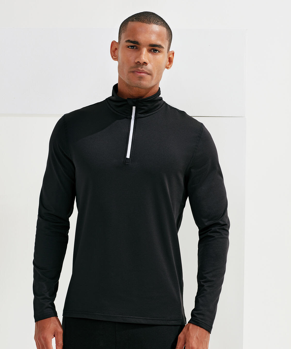 A long sleeve black top with a brushed back finish and a 1/4 zip collar, featuring a small white detail and a logo. Recycled Long Sleeve Brushed Back 1/4 Zip Top - Image 1