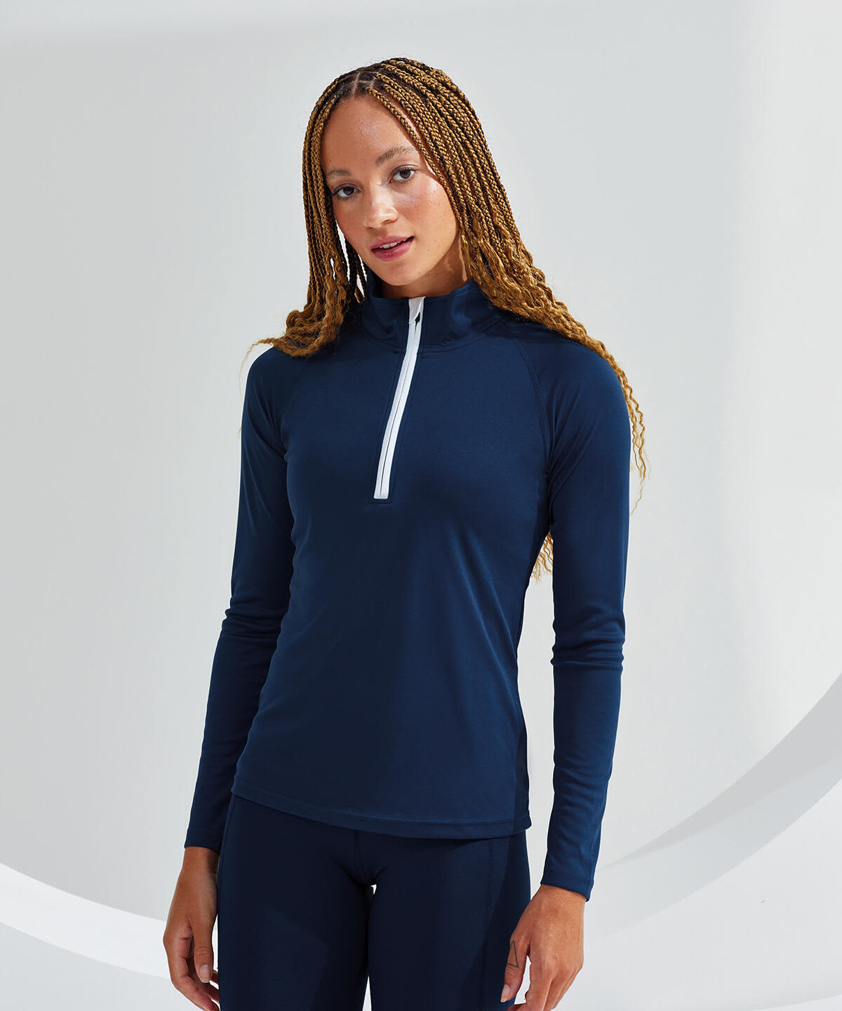 A navy long sleeve performance 1/4 zip top featuring a white zipper and a fitted design. It has a logo on it. Long Sleeve Performance 1/4 Zip - Image 1