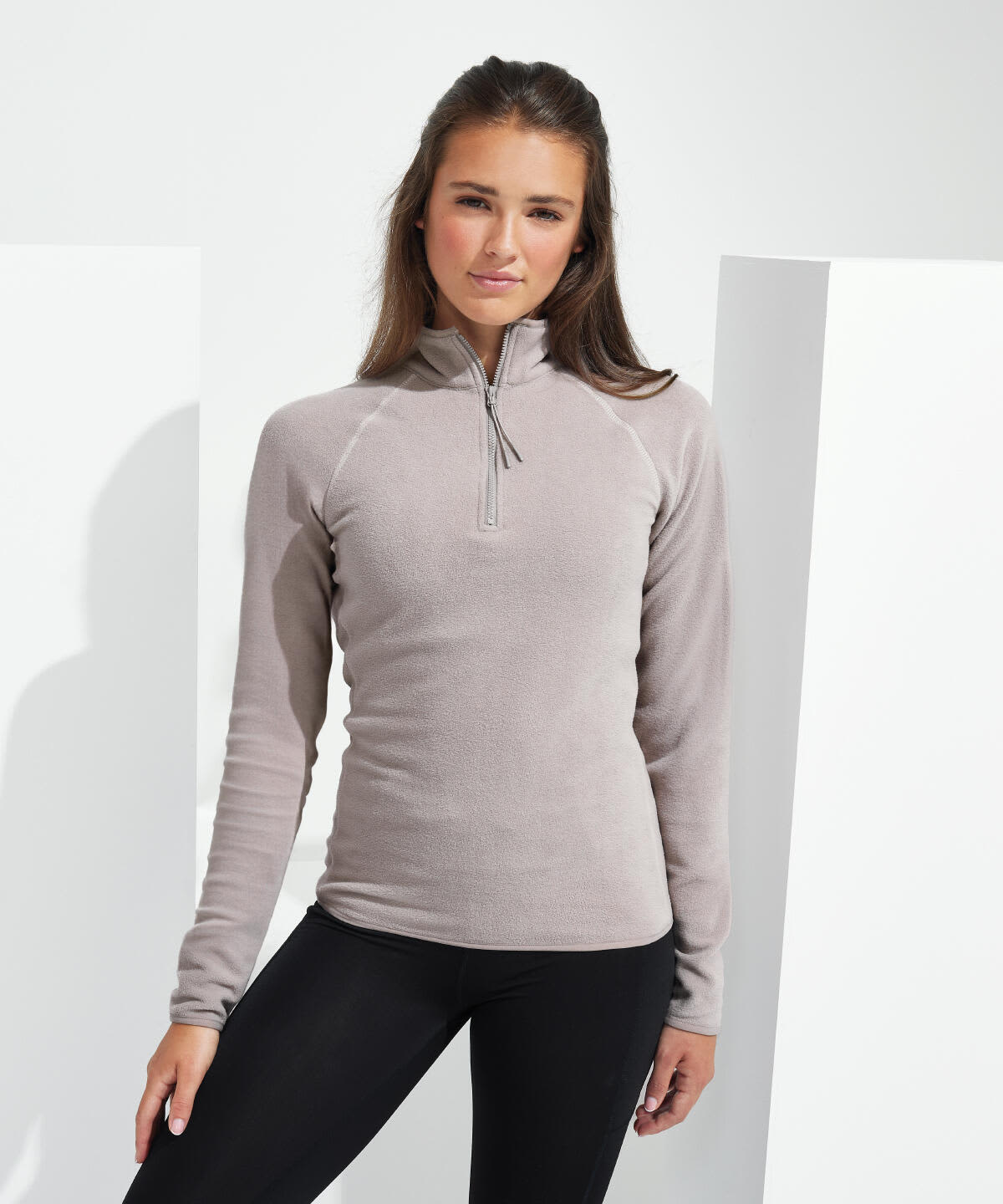 A fitted fleece top in grey with a zip neckline, displayed on a model against a neutral background. Recycled Elements Active-Fitted Fleece - Image 1
