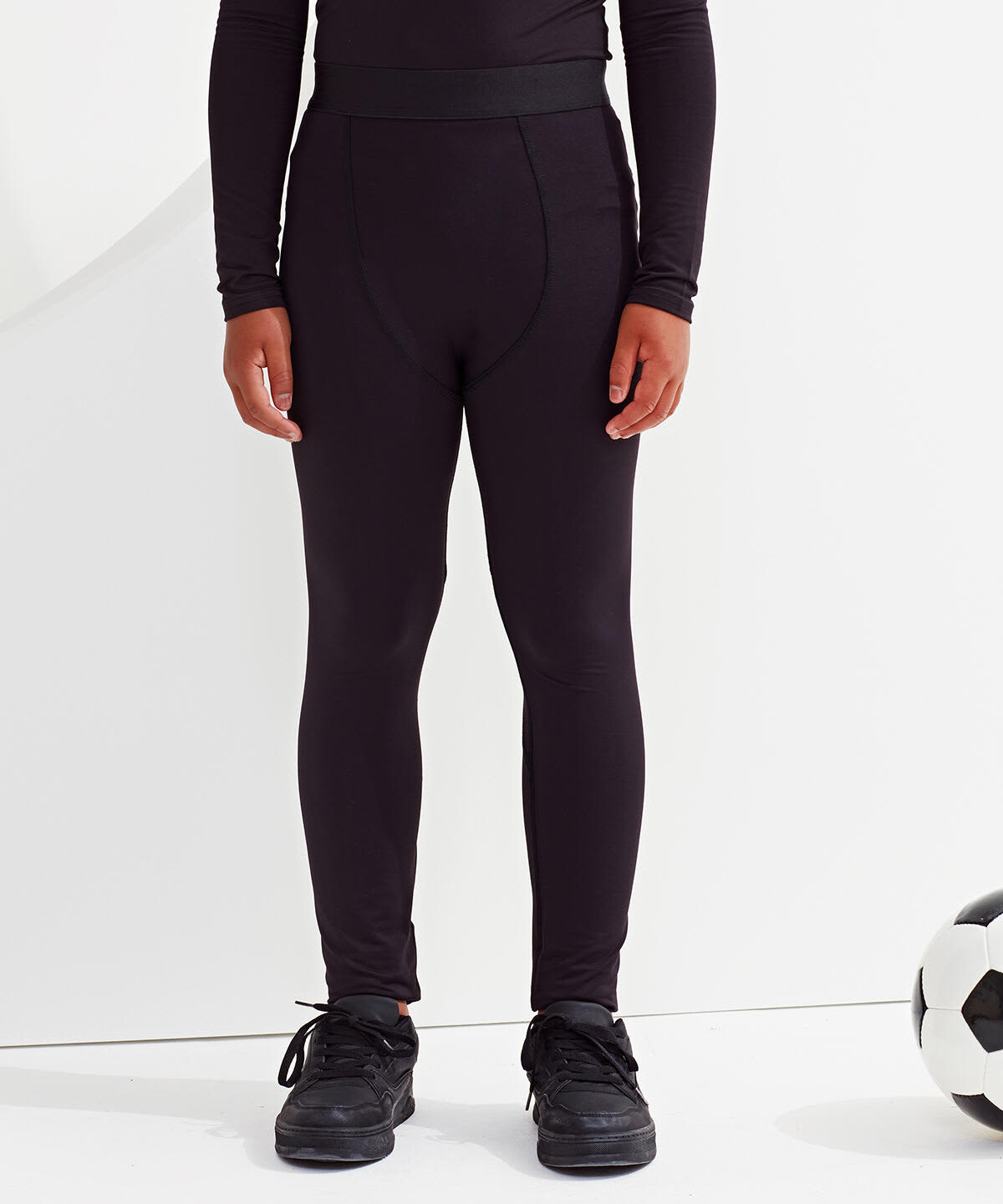 Kids training leggings in black, featuring a fitted design and an elastic waistband, displayed alongside a soccer ball. Kids Training Leggings - Image 1
