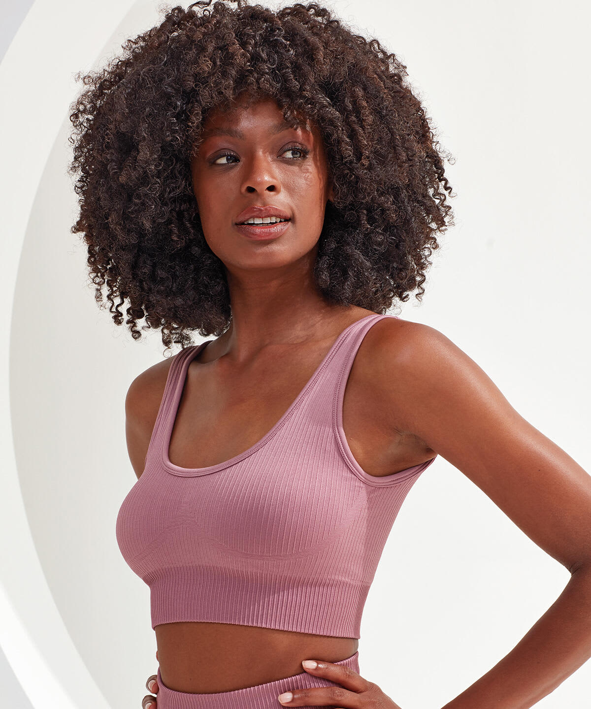 A ribbed, seamless sport bra in a soft mauve hue, featuring a fitted design and wide straps. Ribbed Seamless 3D Fit Sport Bra - Image 1