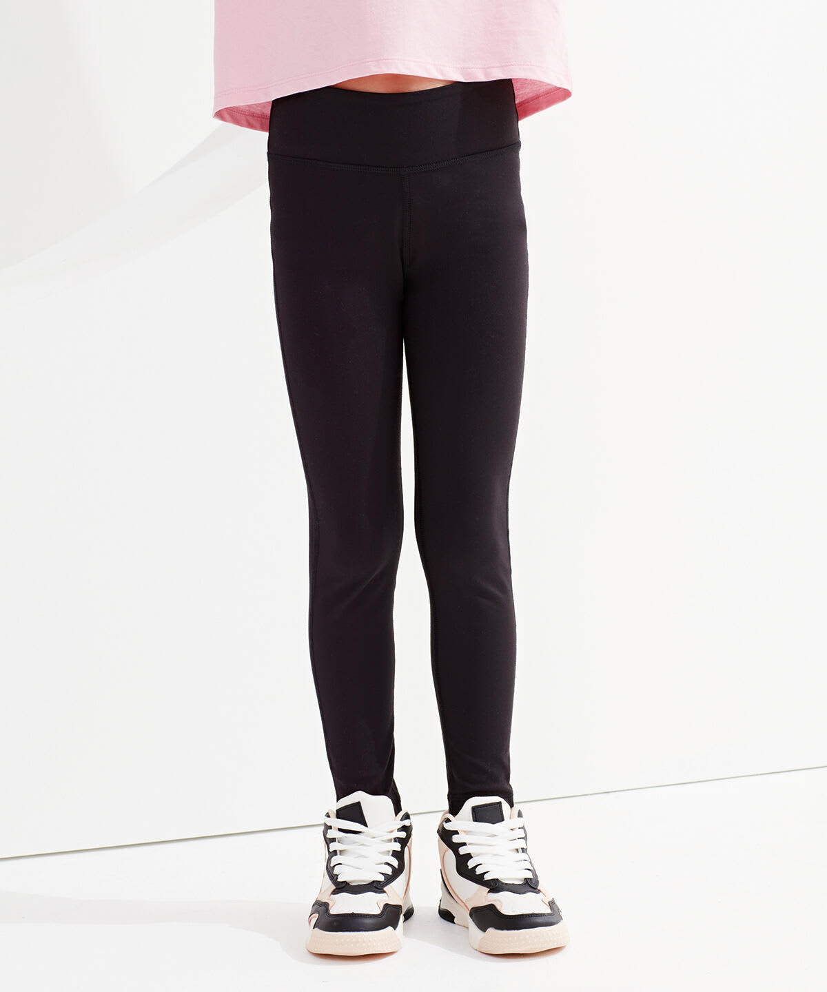 Black recycled performance leggings for kids, featuring a stretchy waistband and a fitted design, paired with sporty shoes. Kids Recycled Performance Leggings - Image 1
