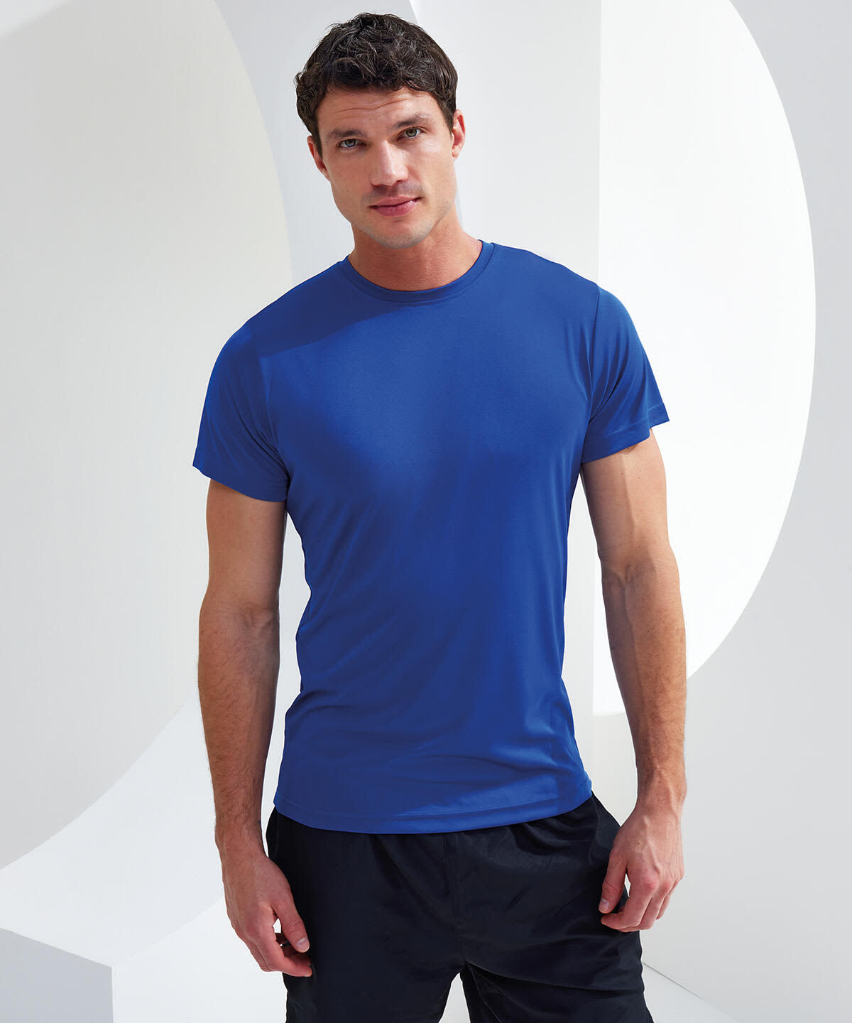 A blue recycled performance T-shirt, displayed on a male model, featuring a simple design and a logo. Recycled Performance T-Shirt - Image 1