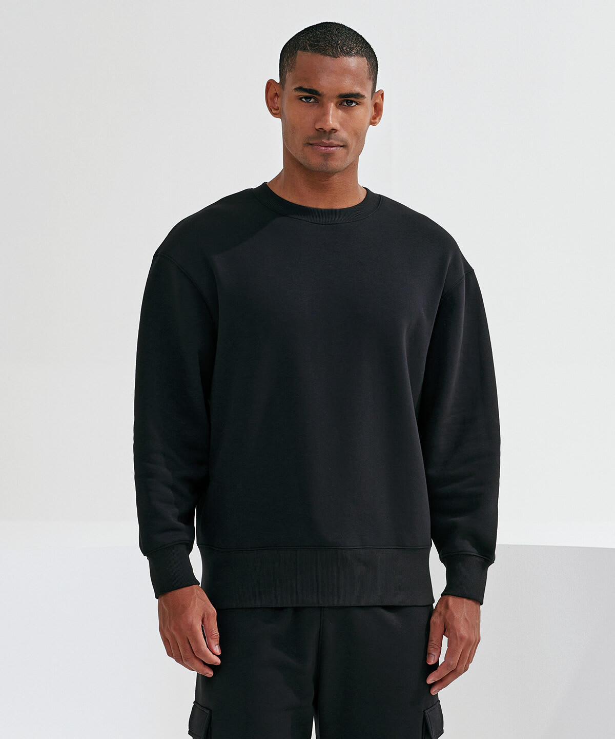 A unisex sweatshirt in black, featuring a relaxed fit and a simple design. It has a logo on the sleeve. Unisex Recycled Sweatshirt - Image 1