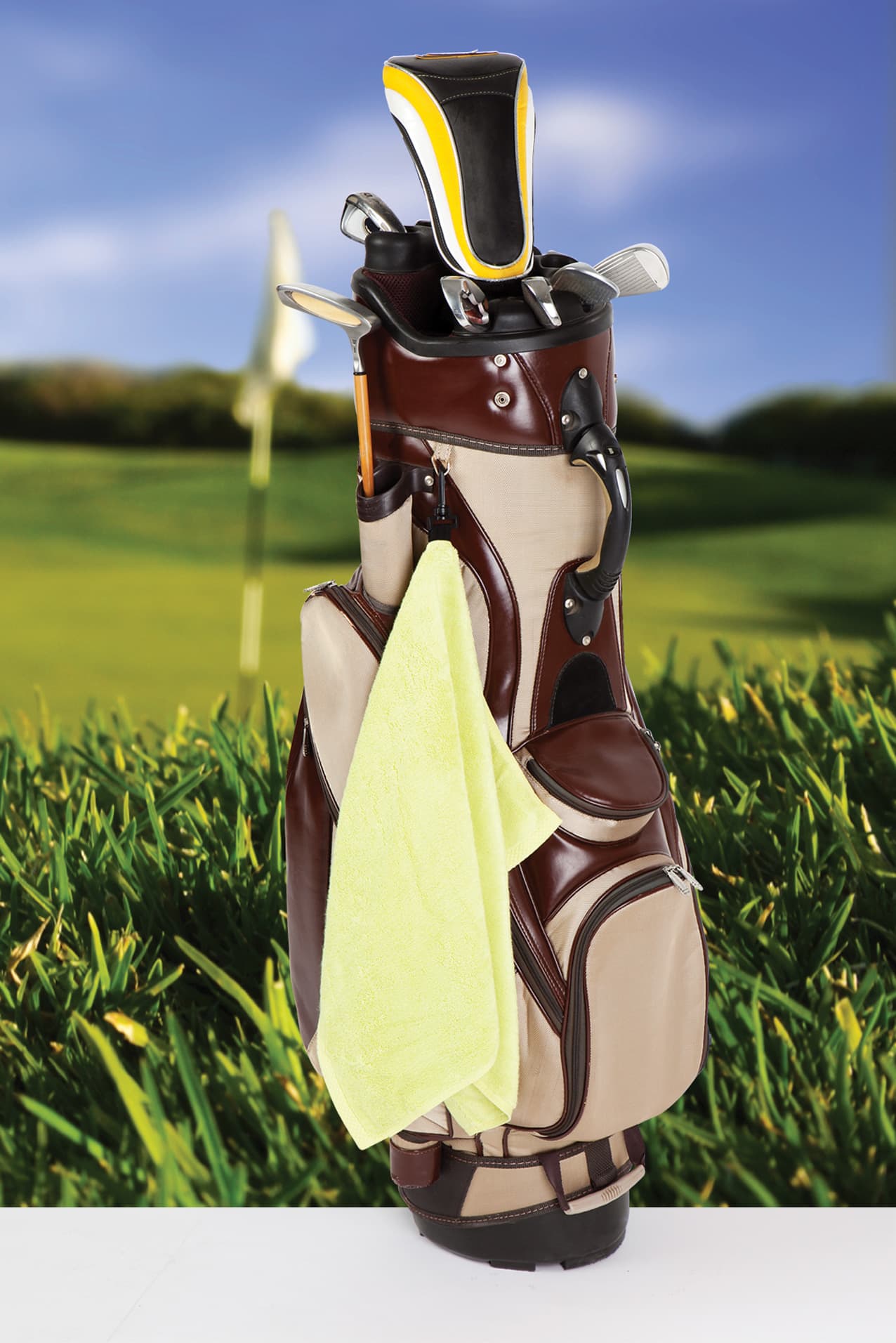 A bamboo golf towel in vibrant yellow, attached to a golf bag with a plastic hook, set against a grassy background. Bamboo Golf Towel with plastic hook - Image 1